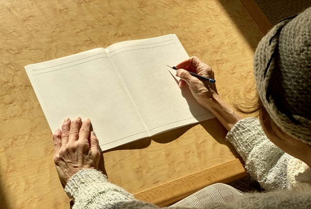 ノートに書く女性高齢者