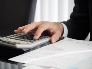 電卓で計算する税理士の手