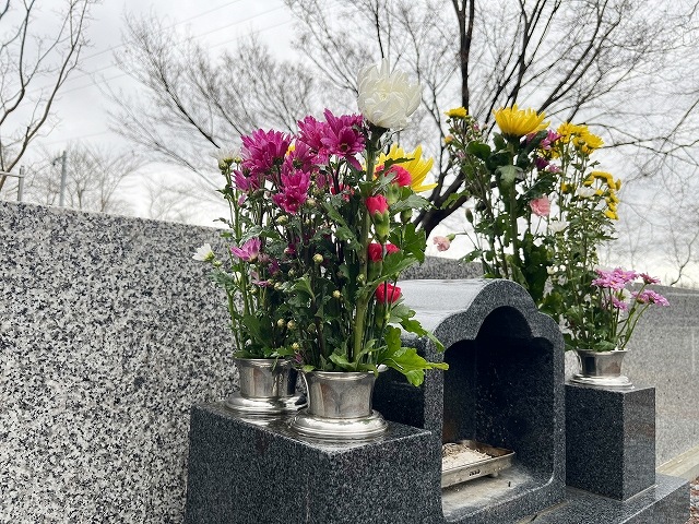 墓前に手向けられた黄色と赤い花-